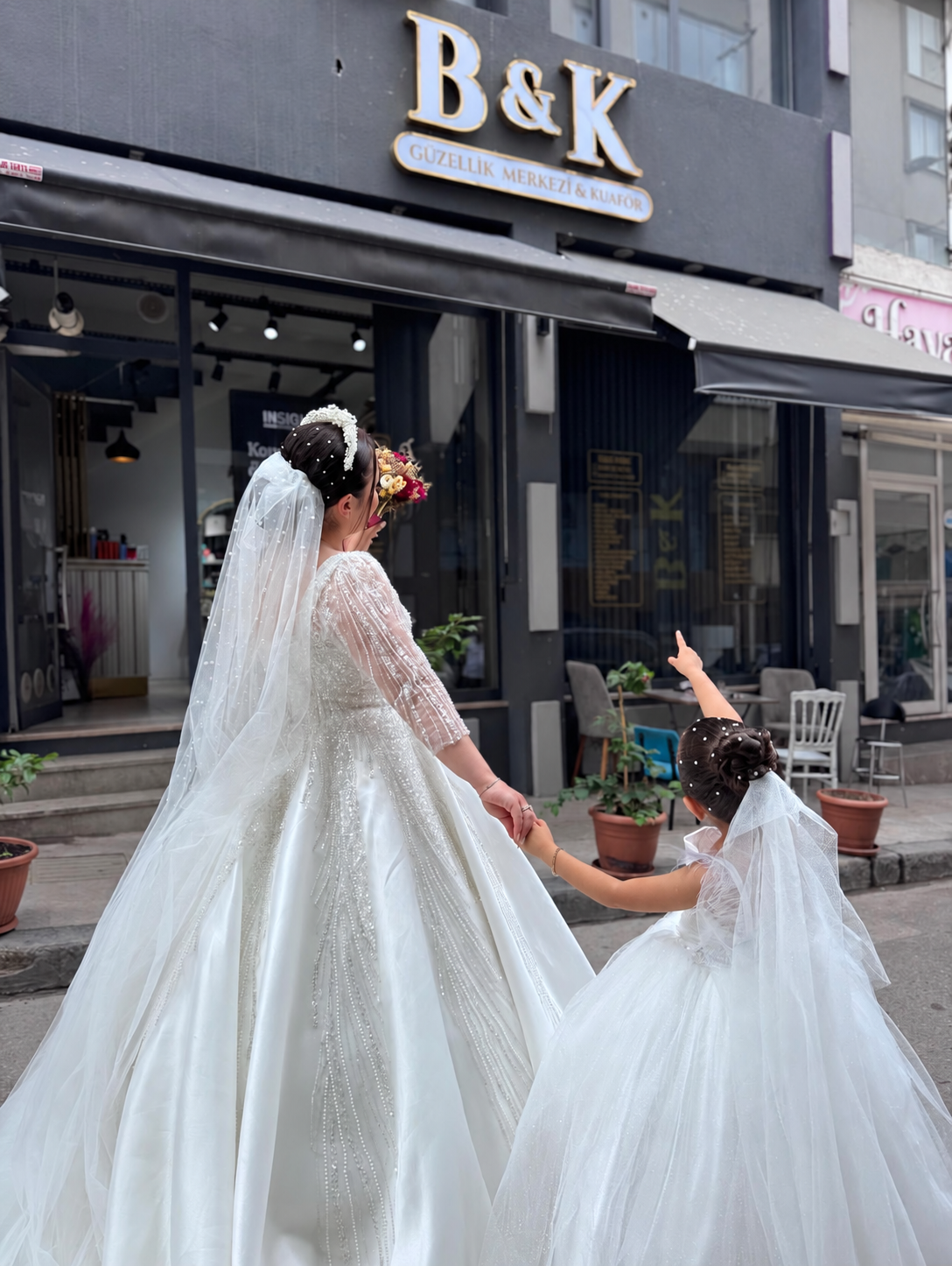 BK salonu önünde duvaklı gelin ve yanında çocuk